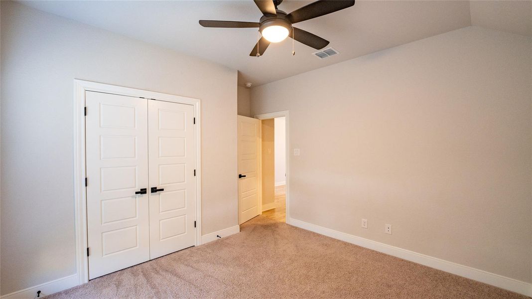 Unfurnished bedroom with carpet, a closet, and ceiling fan Unfurnished bedroom with carpet, a closet, and ceiling fan