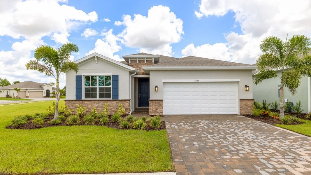 Front exterior of a new home in Coral Bay - Express & Tradition, North Fort Myers, FL, highlighting curb appeal (Image 1).