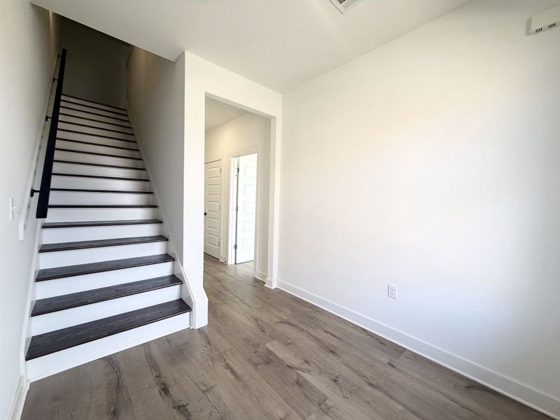 Stairs with wood finished floors and baseboards