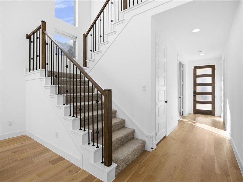 Stairs with wood finished floors and a towering ceiling Stairs with wood finished floors and a towering ceiling