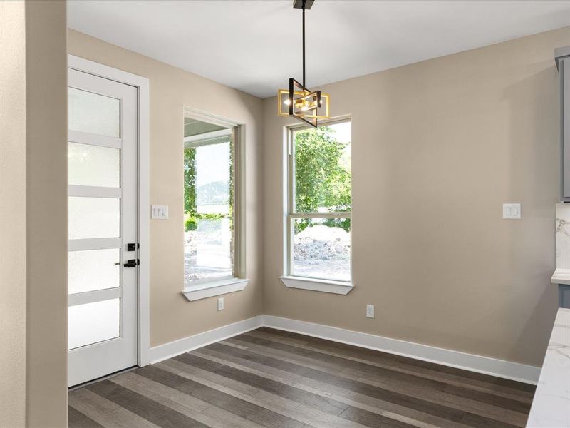 Unfurnished dining area with dark wood finished floors and hanging lights