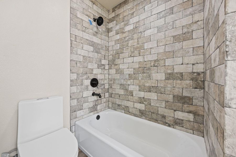 Full bath featuring bathing tub / shower combination and toilet Full bath featuring bathing tub / shower combination and toilet