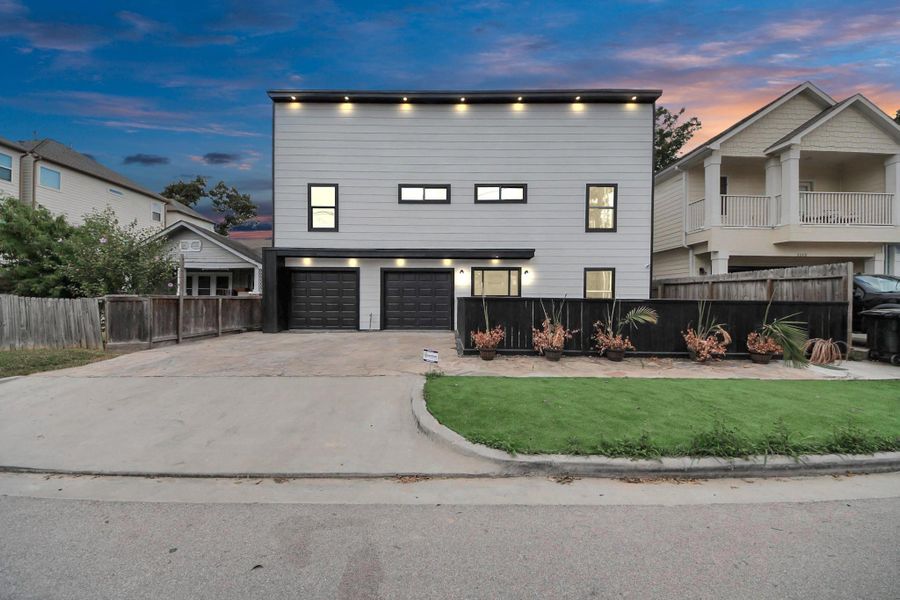 Modern two-story home with clean lines and a sleek design. Features a double garage, private driveway, artificially turfed front yard, and contemporary lighting. Modern two-story home with clean lines and a sleek design. Features a double garage, private driveway, artificially turfed front yard, and contemporary lighting.