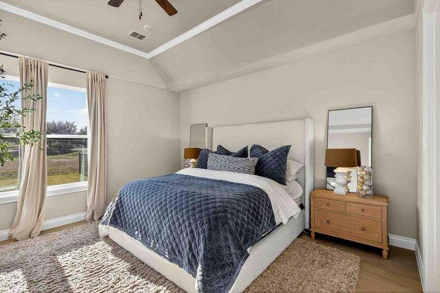 Bedroom with crown molding, wood finished floors, ceiling fan, and vaulted ceiling