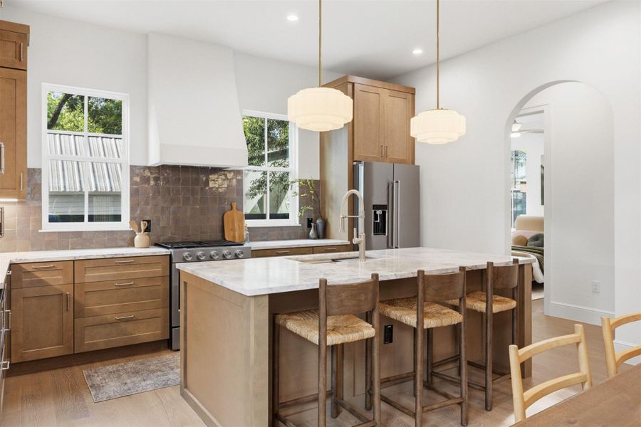 Culinary excellence awaits in this well-appointed kitchen, featuring a spacious island with seating and sleek stainless steel appliances.