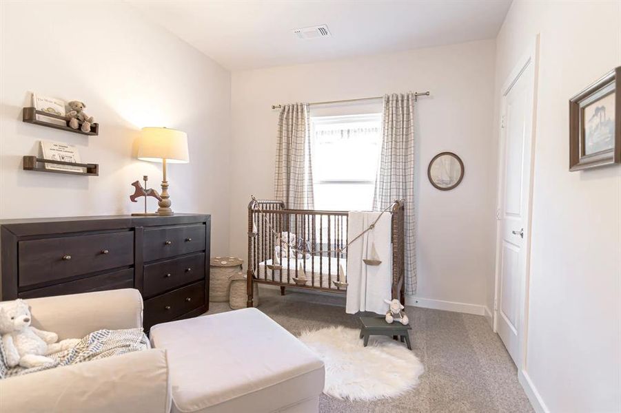 Bedroom featuring a nursery area and light carpet Bedroom featuring a nursery area and light carpet