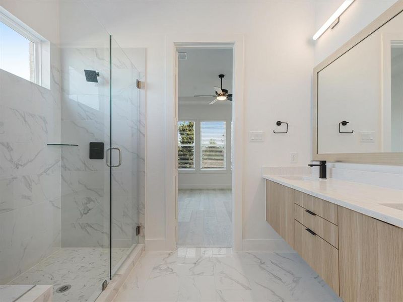Primary Bathroom with healthy amount of natural light, a marble finish shower, light marble finish flooring Primary Bathroom with healthy amount of natural light, a marble finish shower, light marble finish flooring