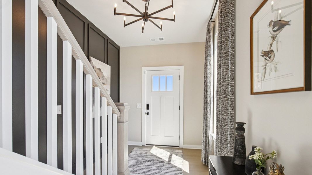 Entry with accent wall, front door, and staircase