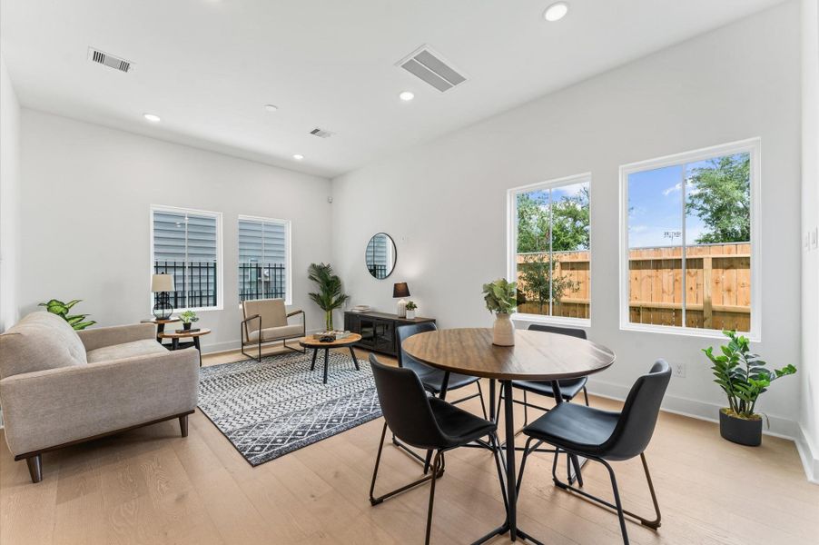 Designed for modern living, this open-concept space seamlessly unites the kitchen, dining, and living areas into one harmonious hub. The kitchen anchors the layout with a large center island, sleek cabinetry, and pendant lighting that adds a touch of sophistication. Just steps away, the dining area offers ample room for gatherings, while the spacious living room invites relaxation with abundant natural light and flexible seating. Designed for modern living, this open-concept space seamlessly unites the kitchen, dining, and living areas into one harmonious hub. The kitchen anchors the layout with a large center island, sleek cabinetry, and pendant lighting that adds a touch of sophistication. Just steps away, the dining area offers ample room for gatherings, while the spacious living room invites relaxation with abundant natural light and flexible seating.