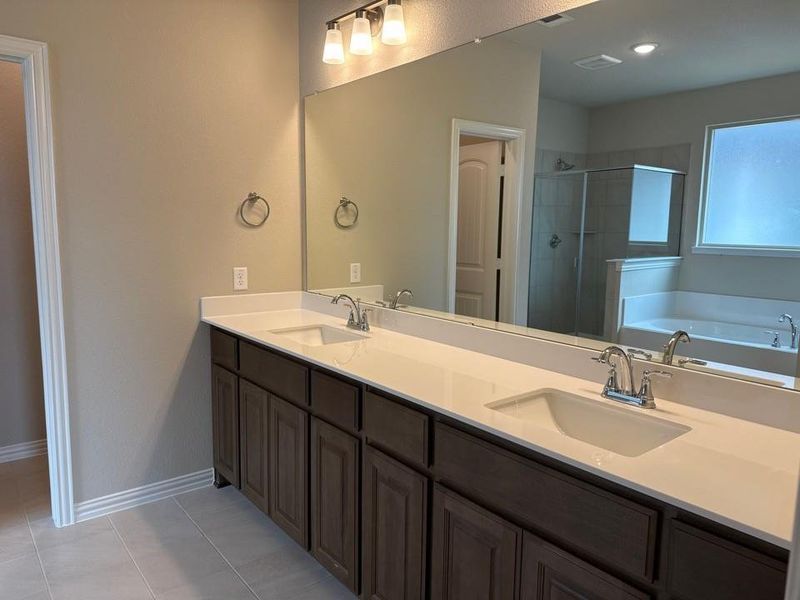 Dual vanity with dark wood cabinetry, white countertops, and undermount sinks