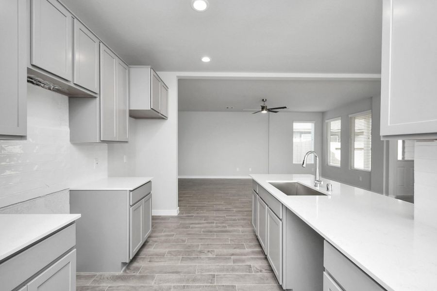 Discover another perspective of this stunning kitchen, generously appointed with an abundance of counter space. Sample photo of completed home with similar floor plan. Actual colors and selections may vary.