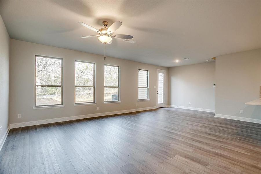 Empty room with ceiling fan and light wood-type flooring