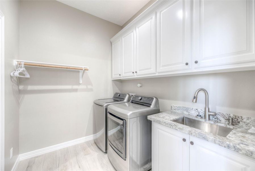 Utility room with plenty of cabinet space, a shelf, and a sink (Building B) Utility room with plenty of cabinet space, a shelf, and a sink (Building B)