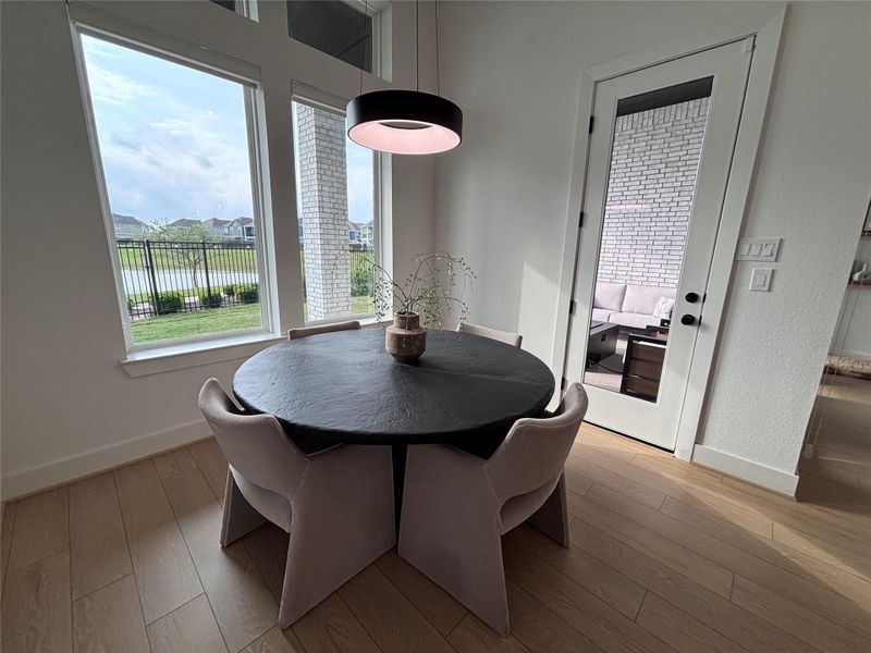The dining area features a large windows offering a scenic outdoor view