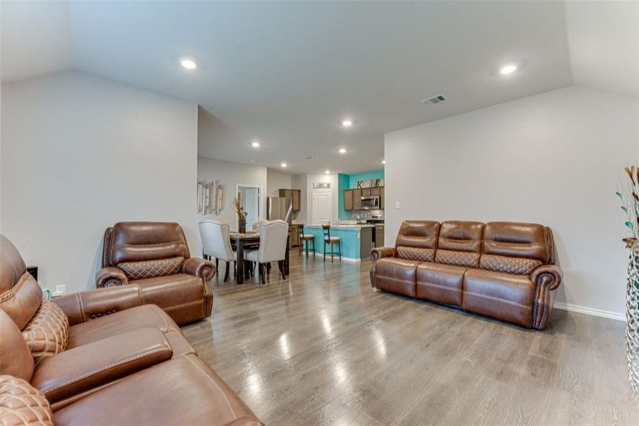 Living room with light hardwood / wood-style flooring and lofted ceiling