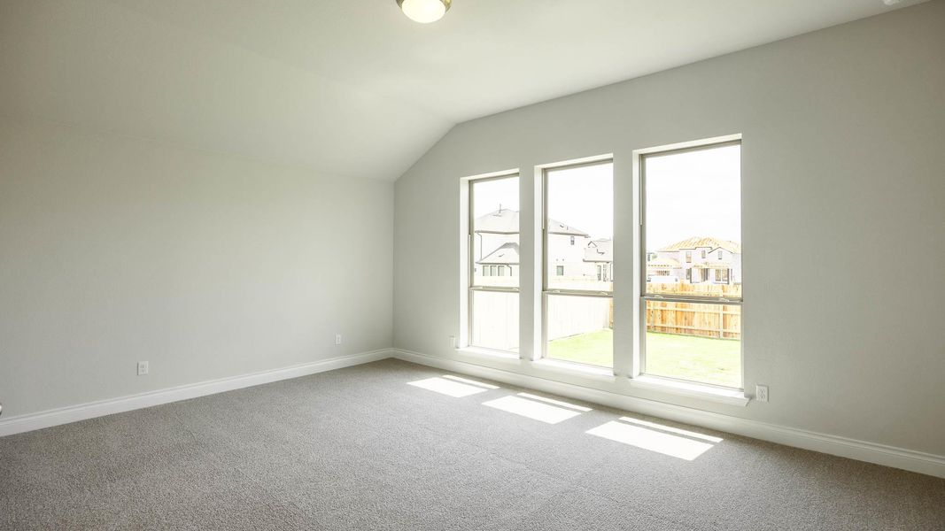 Bonus room with lofted ceiling, carpet flooring, and baseboards Bonus room with lofted ceiling, carpet flooring, and baseboards