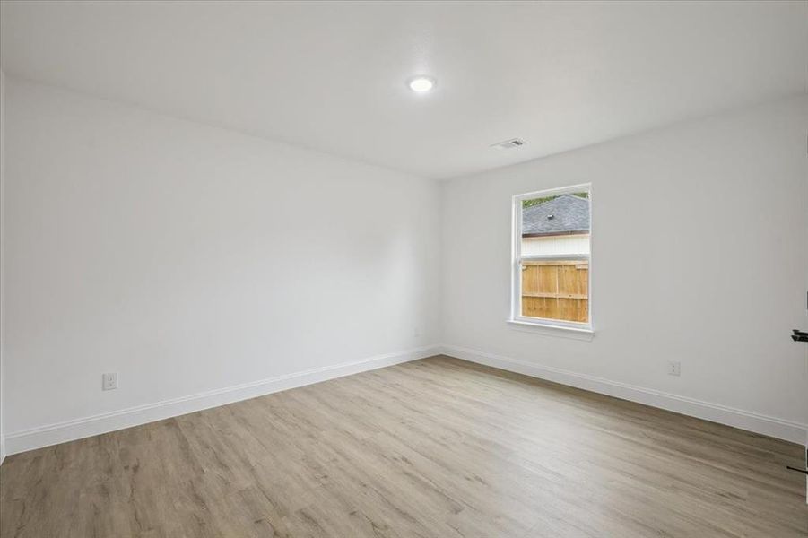 Spare room featuring light wood-style floors and baseboards Spare room featuring light wood-style floors and baseboards