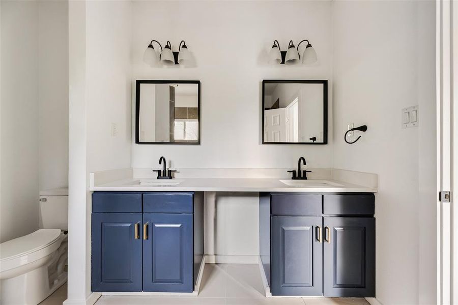 Full bathroom featuring toilet and double vanity