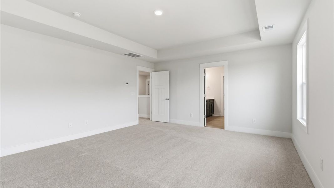 Superior design meets vibrant comfort in this primary suite with carpeted floors and walk-in closet in Gray Court, SC