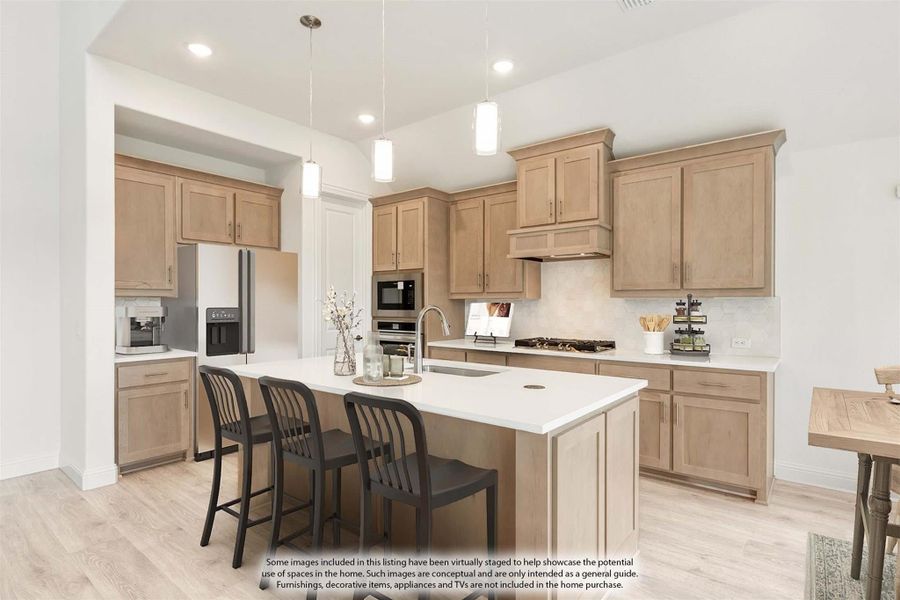 Kitchen with light wood cabinets, center island with seating, pendant lights, and stainless steel appliances