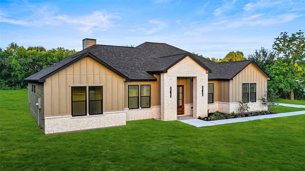 This photo showcases a modern single-story home with a sleek exterior featuring a mix of light brick and siding. This photo showcases a modern single-story home with a sleek exterior featuring a mix of light brick and siding.