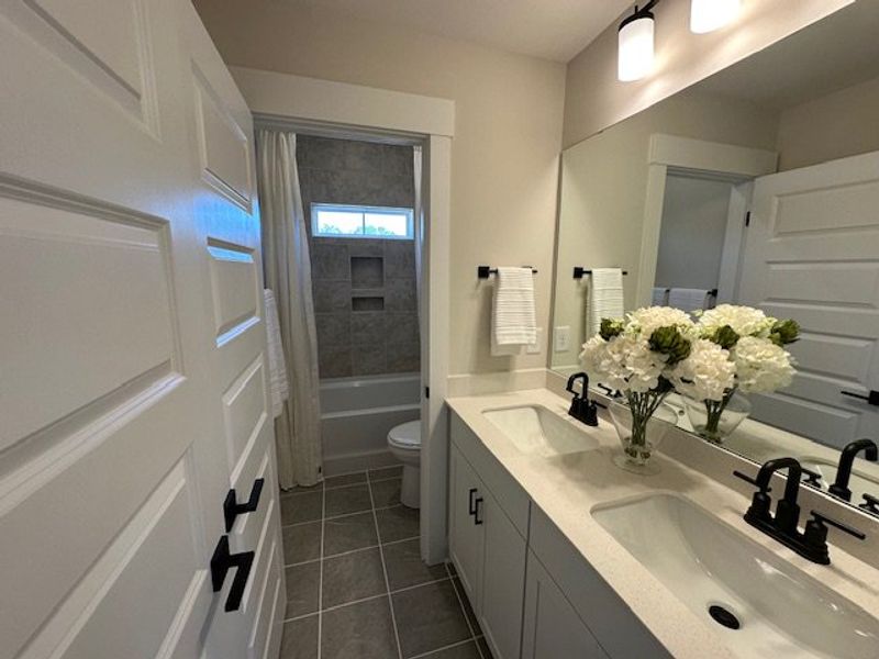 This bathroom features a double vanity and a showe