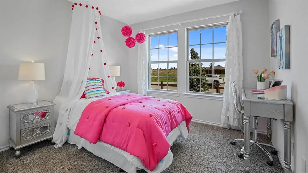Carpeted bedroom featuring two large windows, white trim, and light gray walls