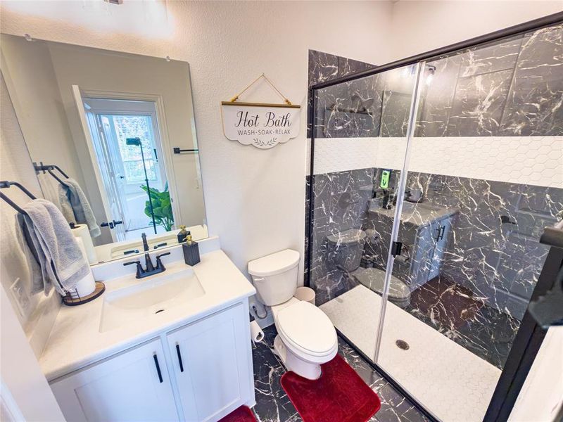 Full bath with vanity and a marble finish shower