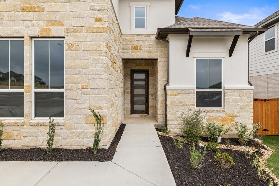 Front exterior of a new home in Capitol Collection at Lariat, Liberty Hill, TX, highlighting curb appeal (Image 1). Front exterior of a new home in Capitol Collection at Lariat, Liberty Hill, TX, highlighting curb appeal (Image 1).