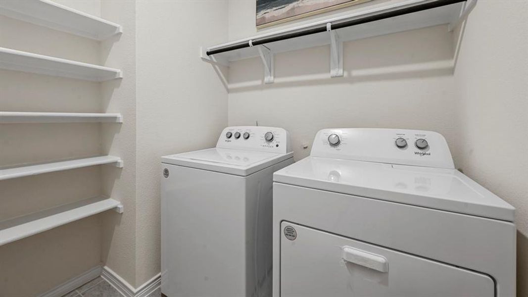 Washroom featuring independent washer and dryer and a textured wall