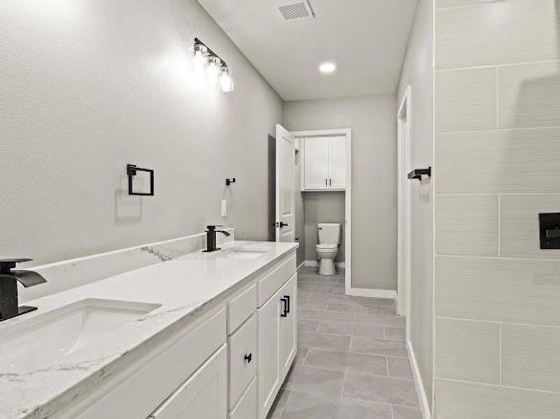 Full bathroom featuring double vanity and recessed lighting