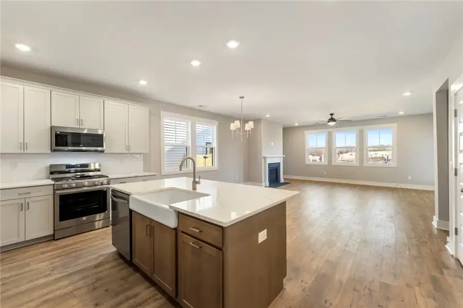 A well-lit open floorplan connects a modern kitche