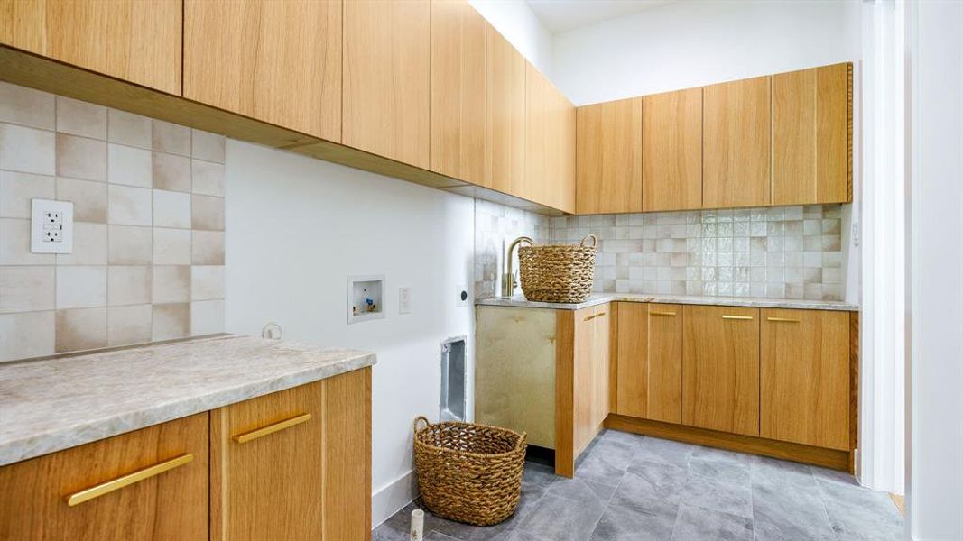 Kitchen with backsplash, light tile patterned floors, and light stone countertops