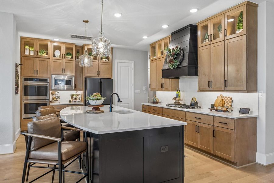 This stunning eat-in kitchen features upgraded GE Cafe appliances, under cabinet lighting, abundant storage and a walk-in pantry. (22 x 14)