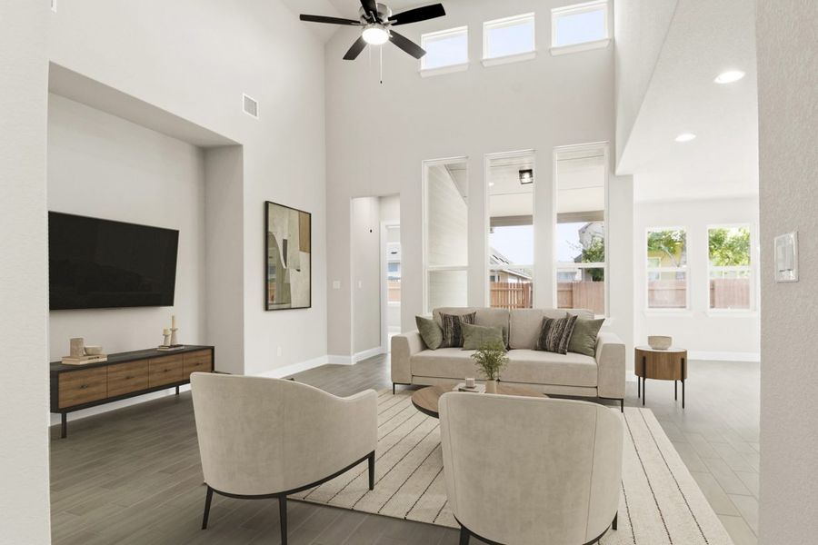 Image of staged living room with beige modern sofas and chairs with a rug and coffee tables along with a TV and TV stand