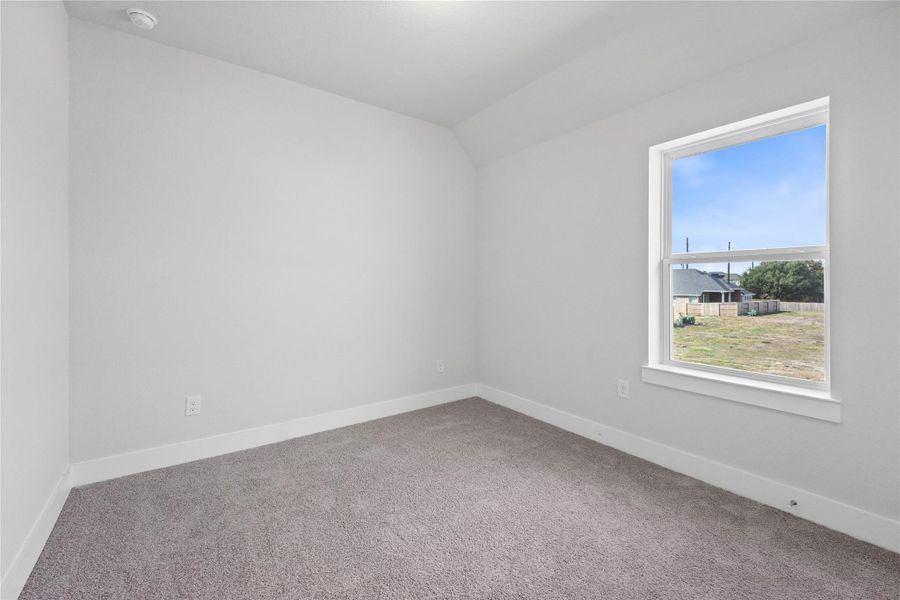 This secondary bedroom offers comfort and style with plush carpeting, neutral paint tones, recessed lighting, a large window, and a generously sized closet.