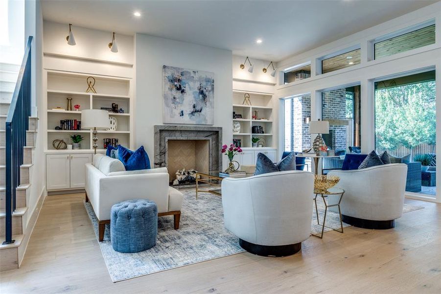 living room with custom built-ins, lighting and open view of patio and backyard