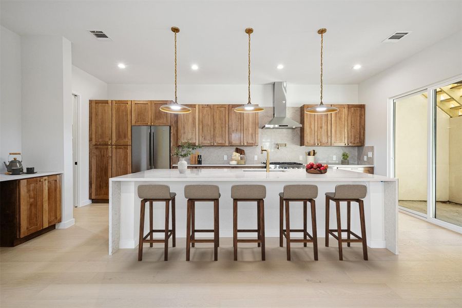 Kitchen with a kitchen bar, light stone countertops, and a large island with sink