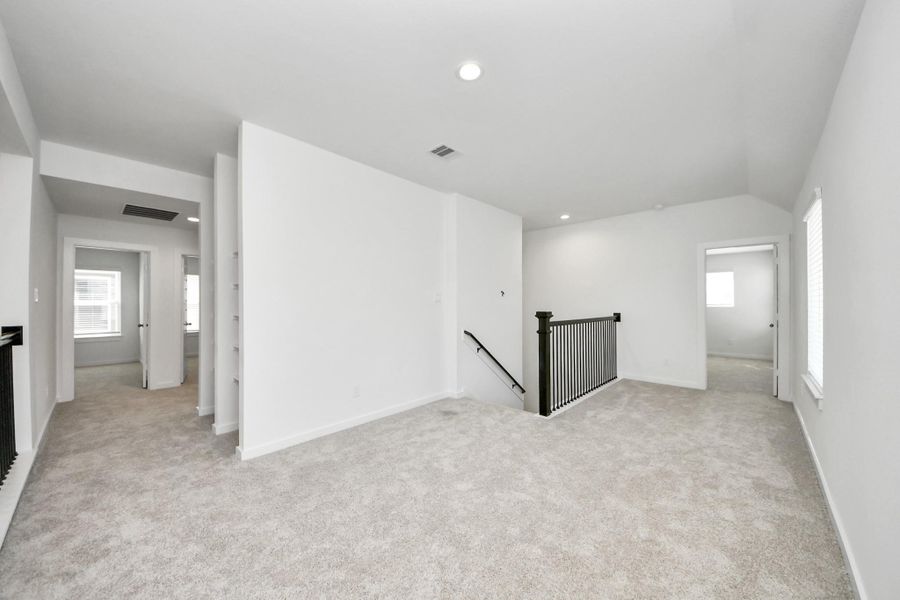 Ascend to relaxation in this fantastic game room! Ideal for both casual gatherings and adult gaming, it boasts plush carpet, lofty ceilings, custom paint, and ample windows for abundant natural light. Sample photo of completed home with similar floor plan. Actual colors and selections may vary.