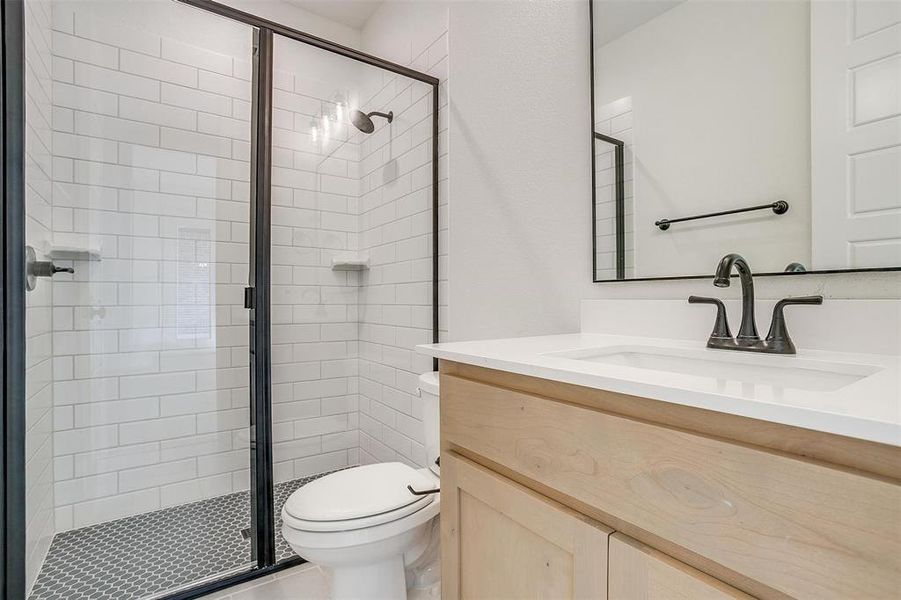 Bathroom featuring vanity, an enclosed shower, and toilet