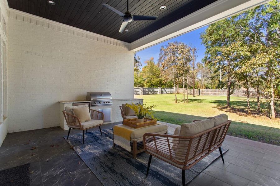 Fenced backyard featuring outdoor lounge area, a patio, ceiling fan, and area for grilling