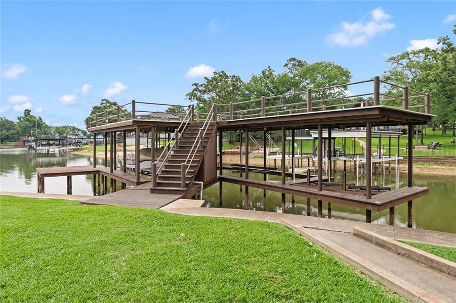 Large covered boathouse with two boat slips, jet ski slip, and direct lake access—perfect for boating, fishing, or watersports.