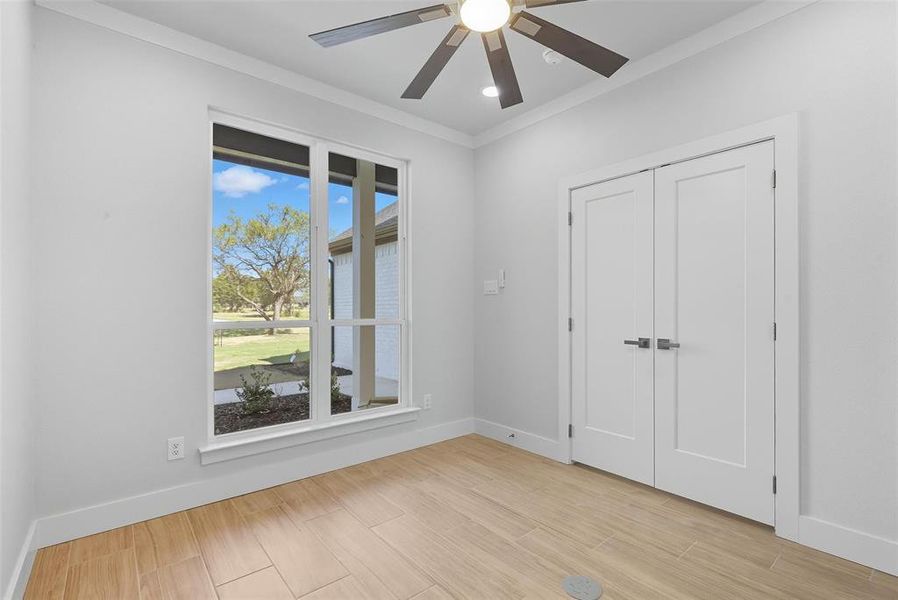 Unfurnished bedroom with ornamental molding, ceiling fan, light wood-style floors, a closet, and recessed lighting Unfurnished bedroom with ornamental molding, ceiling fan, light wood-style floors, a closet, and recessed lighting