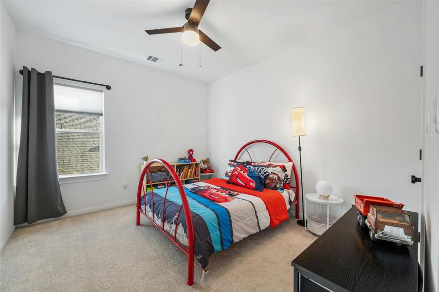 One of two secondary bedrooms upstairs, this spacious bedroom comes with a modern overhead fan and a walk-in closet.