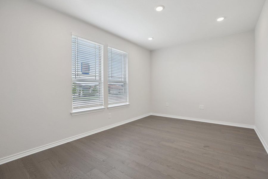 Unfurnished room with wood finished floors and recessed lighting