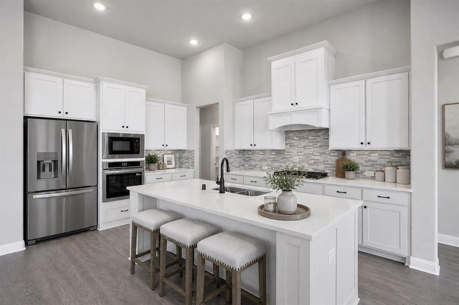 Designer kitchen featuring quartz countertops, oversized island, gas cooktop, and built-in stainless appliances.
