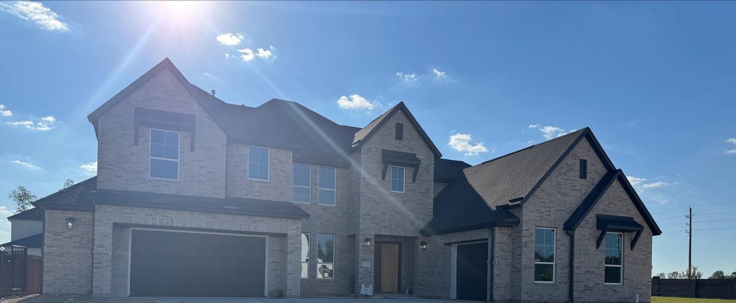 Front exterior of a new home in Woodson’s Reserve 80′, Spring, TX, highlighting curb appeal (Image 1).