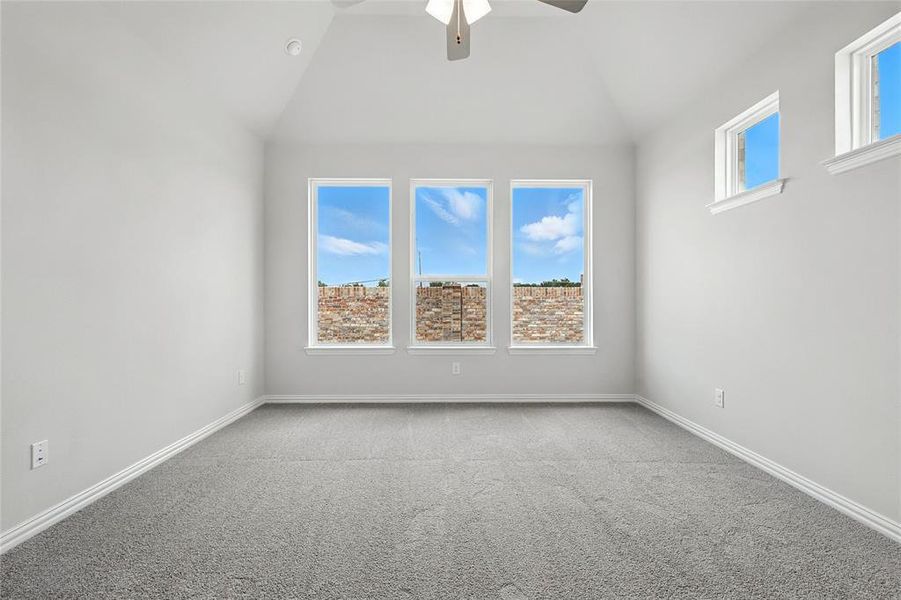 Unfurnished room featuring lofted ceiling, a ceiling fan, and carpet flooring Unfurnished room featuring lofted ceiling, a ceiling fan, and carpet flooring