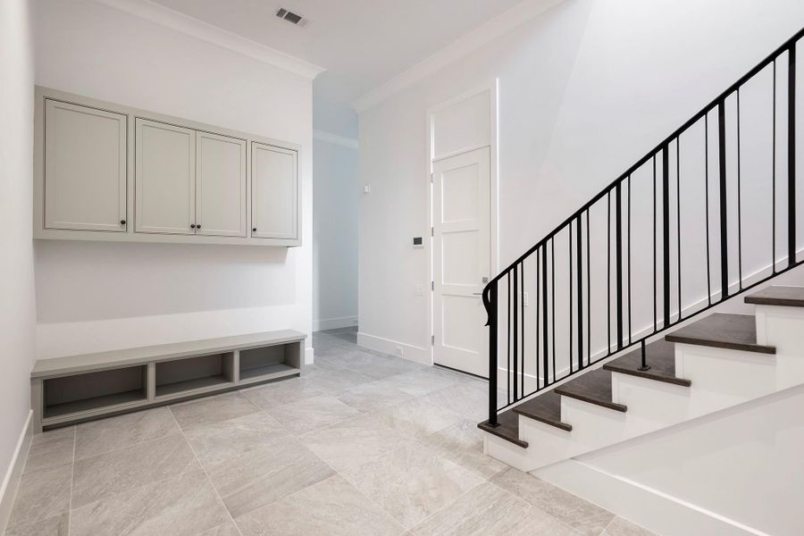 Mud room off the garage with built-in storage. Second staircase to upstairs.