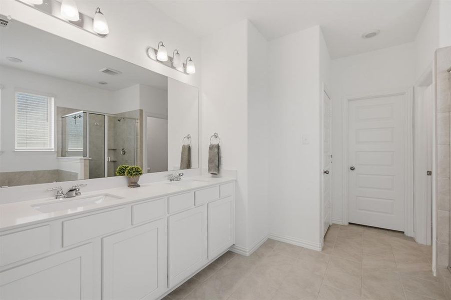 Large primary vanity with dual sinks, bright lighting, and excellent storage. The primary bath offers space, comfort, and convenience.